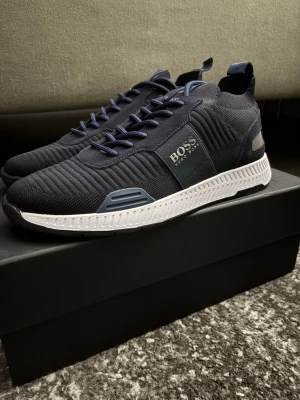 Hugo boss skor - Hugo boss titanium runn mörkblå.  Storlek 42 kan även passa de som har 43.  Skorna är aldrig använda endast testade. Påse box allt medföljer vid köp.