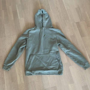 Grön hoodie med ficka och huva - Snygg grön hoodie med stor känguruficka framtill och justerbar huva med snörning. Tröjan har långärmade ärmar och ribbade muddar vid ärmslut och nederkant. Perfekt för chill dagar och enkel att matcha med jeans eller joggers. Skriv vid frågor🙋‍♂️