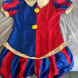 Pomni cosplay - Pomni cosplay från TADC använd bara två gånger har alting på utan wig. har puffiga korta ärmar, rund krage och två stora gula bollar framtill. puffig med breda ränder. 
