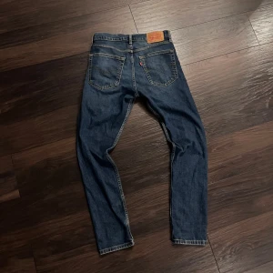 Levi's 515 slim fit jeans blå W30 L32 - Säljer ett par Levi's 515 slim fit jeans i klassisk blå denim. Jeansen har en tapered passform, fem fickor och snygga slitningar framtill. Typisk Levi's-lapp bak i midjan och röda Levi's-tag på bakfickan. Perfekta för dig som gillar en smalare siluett. Känn dig helt fri att ställa frågor och skicka prisförslag. Skickar inom 24h