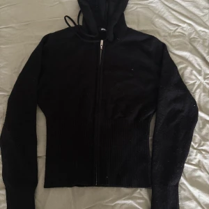  stickad zip hoodie - Svart stickad zip hoodie från Gina tricot, breda muddar vid ärmarna och längst ner, använd fåtal gånger 