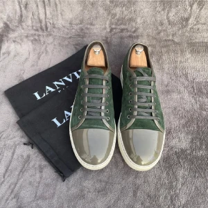 Gröna sneakers från Lanvin i mocka - Snygga gröna sneakers från Lanvin med ovandel i mocka och glansig tå i olivgrönt. Skorna har grå snörning och vit platt sula. Perfekta för dig som vill ha en unik och stilren look med lyxig känsla.