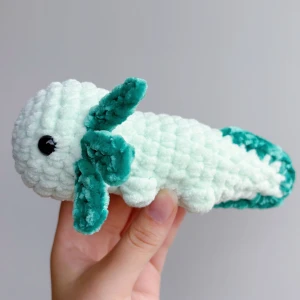 Virkad grön axolotl - Grön virkad axolotl – handgjord & unik💚🧶 Superfin, mjuk och söt liten axolotl i grön, perfekt som present eller för att ge lite extra charm till hyllan, soffan eller skrivbordet! 	•	Handgjord med kärlek 💚 	•	Virkad i mjukt garn 	•	Ca 17-18cm lång 	•	Unik – bara ett exemplar!  ✨ Pris: 150 kr ✨  Passar både som prydnad och kramdjur 🧸OBS! Dessa innehåller säkerhetsögon som ej är rekommenderade för barn under 3 år!
