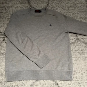 Grå Morris merinoulltröja  M - Snygg grå stickad tröja från Morris i 100% merinoull. Klassisk modell med rund hals, ribbade muddar och diskret broderad logga på bröstet. Perfekt för dig som gillar stilrena och bekväma plagg. Nytt skick passar S-M. Nypris 1500, mitt pris går att diskutera 
