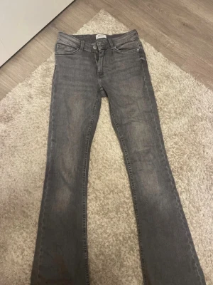 Grå bootcut jeans från ONLY - Snygga grå jeans från ONLY med bootcut passform. Klassisk femficksmodell och normal midja. Jeansen är tillverkade i mjukt denimtyg som ger en bekväm känsla. Använda få gånger och har inga slitage.