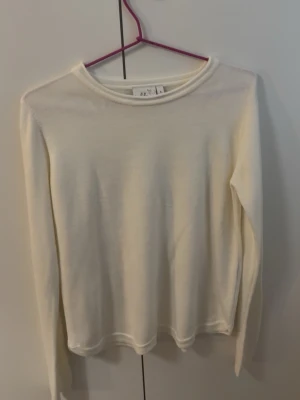 Vit finstickad tröja - Vit stickad tröja från Isolde med rund halsringning. Tillverkad i ett mjukt och tunt material som passar perfekt för lager på lager. Enkel och stilren design som funkar till det mesta.