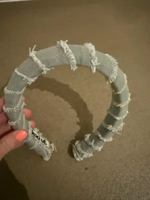 Ljus grön vadderat diadem med fransar - Säljer ett trendigt ljus grön diadem från lexi uf Diademet är vadderat och täckt med tyg i denim-look och har råa franskantsdetaljer som ger en cool och avslappnad vibe. Perfekt accessoar för att lyfta din outfit.