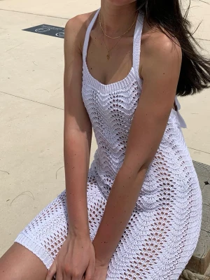 Vit virkad strandklänning -  vit virkad strandklänning med halterneck och öppen rygg. Klänningen passar både XS och S. Har en till exakt likadan i brun om det är intressant. 
