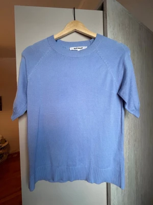 Ljusblå tröja från Soft Rebels - Supersnygg ljusblå tröja från Soft Rebels med korta ärmar och rund hals. Tröjan har ribbade detaljer vid hals, ärmslut och nederkant. Perfekt till jeans eller kjol för en chill och stilren look.
