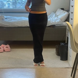 Svart långkjol i mjukt material - Säljer en fin elegant svart långkjol med figurnära passform. Kjolen är lite ribbad, i stretchigt material och endast använd en gång. Står xxs men passar även xs och s💖