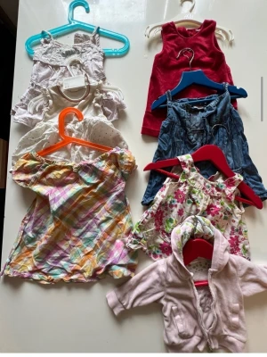 Stort paket med babykläder mix stl 50/68 - Säljer ett paket med babykläder i olika färger och mönster. Innehåller klänningar, bodys, byxor, en hoodie och toppar. Färgerna är bland annat rosa, röd, blå, vit, blommigt och rutigt. Materialen varierar mellan bomull och denim. Perfekt för dig som vill ha en varierad garderob till din bebis.