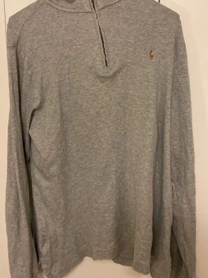 Grå långärmad tröja från Polo Ralph Lauren - Snygg långarmad från polo Ralph lauren med färgen grå. Tröjan är perfekt till våren då den är tunn och inte så tjock. Varan köptes för 700kr och priset kan diskuteras. Hör gärna av dig om du är intresserad av att köpa.