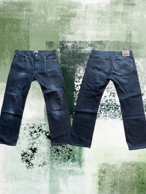 Svarta Levis 501 jeans - Säljer ett par svarta klassiska Levis 501 jeans. Jeansen har snygga fades och inga slitningar. Storlek W36 L36 men är ganska korta så jag skulle snarare säga L32. Passformen är relativt avslappnad. Perfekta till en avslappnad stil och funkar året runt. Fråga om du undrar något! Priset går att diskuteras!