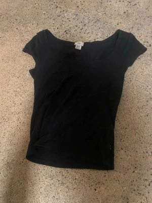 Svart croppad topp från BDG - Snygg svart croppad topp från BDG med bred urringning och korta ärmar. Tillverkad i mjuk ribbad bomull som sitter tight och framhäver figuren. 