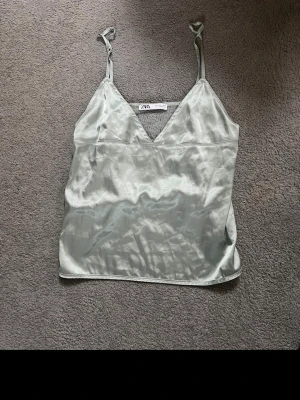 Ljusgrön satinlinnetopp från Zara - Säljer en ljusgrön linnetopp från Zara i glansigt satinmaterial. Toppen är instorlek L men passar även mig som brukar ha xs!🤍🌷