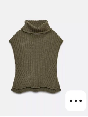 Olivgrön ribbad polotröja Zara - Säljer en olivgrön ribbstickad polotröja utan ärmar. Tröjan har hög krage och en avslappnad passform med snygga diagonala ribbdetaljer. Perfekt för lager på lager och ger en trendig look till din outfit.