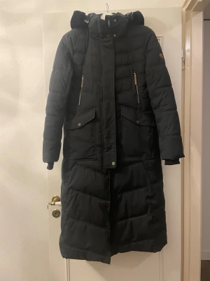 ELT ridkappa, ridjacka, stalljacka, storlek S - ELT ridkappa, ridjacka, stalljacka, storlek S, skulle säga 38. Bra fyllning som håller en varm i kylan. Två dragkedjor bak samt resår att spänna över benen vid ridning. Lite smuts som går bort i tvätt eller med en trasa. Bästa ridjackan! Hann inte använda den så mycket innan jag slutade med hästar. 