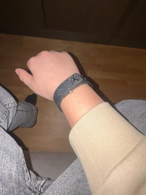 Louis Vuitton monogram armband - Snyggt armband från Louis Vuitton i mörkgrått läder med klassiskt monogrammönster. Justerbar längd med flera hål för perfekt passform. Perfekt accessoar för dig som gillar exklusiv och trendig stil.