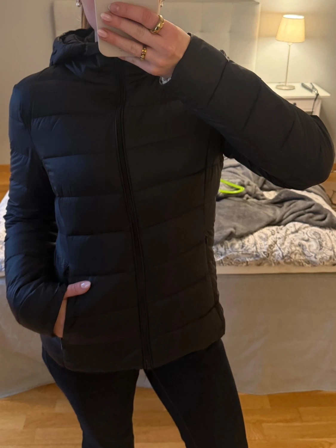 Svart figursydd jacka med luva