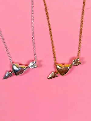 Halsband med hjärta och pil från L8hasselblad - Snyggt halsband med ett hjärta genomborrat av en pil. Finns i både guld- och silverfärg. Kedjan är tunn och smidig, och hänget har en blank, metallisk finish. Perfekt accessoar för att ge en romantisk touch till din stil. Från l8hasselblad och köpt för 700 men säljer för 420 pågrund av att själva hjärtat har blivit lite silvrigt❤️