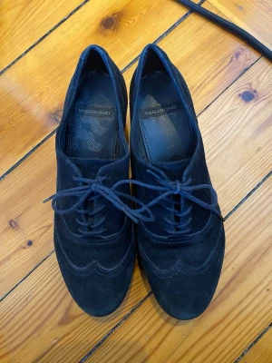 Svarta platåskor från Vagabond - Snygga svarta platåskor från Vagabond i mocka med snörning och rund tå. Skorna har en rejäl plattformsula som ger extra höjd och en cool look. 