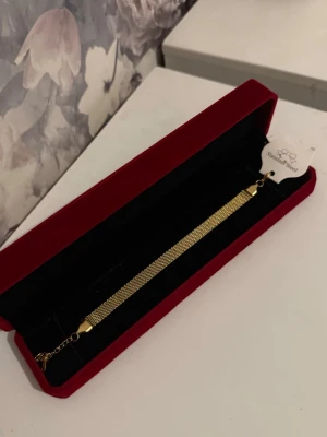 Guld Armband X-Länk - Helt ny aldrig använd. Rostfritt stål. Justerbar