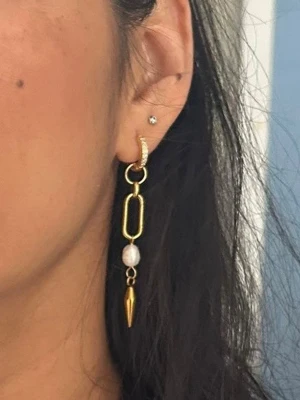 Guldiga örhrängen med sötvattenpärla - Priset avser ett par örhängen. Material: Guldpläterat rostfritt stål och sötvattenpärla Längd: ca 6,5 cm Nickelfria och handgjorda