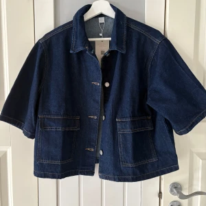 Kortärmad jeansjacka - Helt ny jeansjacka halvärmar till salu då den inte används och jag ångrar mitt köp. Köpt för 399.