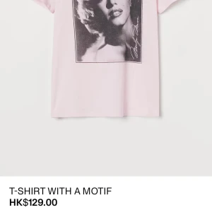 Ljusrosa t-shirt med Marilyn Monroe-tryck - Snygg ljusrosa t-shirt med stort svartvitt tryck av Marilyn Monroe på bröstet. Nypris 129$/1200 kr  Klassisk passform med korta ärmar och rund hals. Perfekt statement-plagg för dig som gillar ikoniska motiv och vill sticka ut lite extra. 