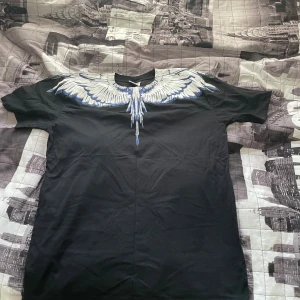 Svart t-shirt med vingeprint - Marcelo Burlon t shirt i storlek L, knappt använd då den är för stor 
