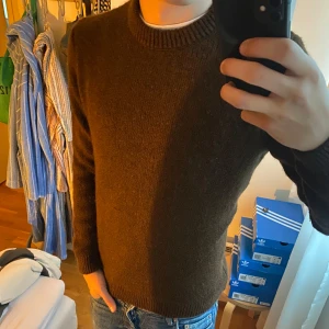 Brun stickad tröja från ASOS DESIGN - Mysig brun stickad tröja från ASOS DESIGN i storlek S. Tröjan har rund halsringning, ribbade muddar och är långärmad. Perfekt för lager-på-lager och chill höst- eller vinterstil. Enkel och stilren design som funkar till jeans eller chinos.