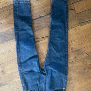 Levi's 512 mörkblå jeans W28 L30 - Säljer ett par Levi's 512 jeans i mörkblå denim. Modellen har smal passform med klassiska bakfickor och gul kontrastsöm. Perfekta för dig som gillar en stilren och tidlös look. Materialet är slitstarkt jeans och midjan är normal.