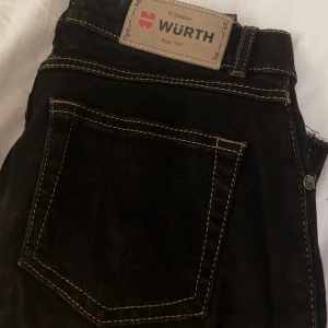 Svarta jeans från Würth med kontrastsömmar - Svarta jeans från Würth med snygga kontrastsömmar i gult. Modellen har rak passform och Low waist. 