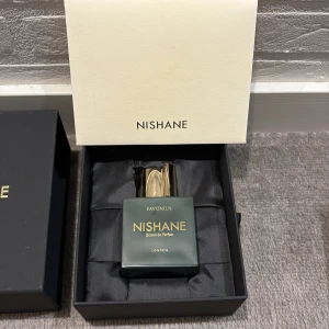 Nishane Favonius Extrait de Parfum - Lyxig parfym från Nishane, modellen Favonius Extrait de Parfum. Flaskan är fyrkantig i mörkgrön färg med guldfärgad text och ett exklusivt guldfärgat lock. Kommer i elegant svart presentask med silkigt foder och stilren förpackning.