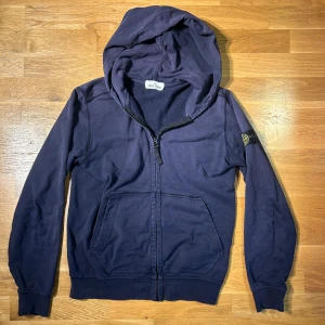 Stone Island hoodie  - Säljer en marinblå hoodie från Stone Island med dragkedja och huva. Använd mycket, finns defekter på båda armarna samt på bröstet. Storlek S, den är riktig                 ✅Skriv för frågor eller mer bilder ✅
