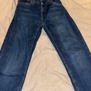 Levi's 512 Slim Taper jeans blå - Säljer ett par Levi's 512 Slim Taper jeans i klassisk mörkblå denim. Jeansen har smal passform med avsmalnande ben, snygga kontrastsömmar och fem fickor. Perfekta för dig som gillar en modern och stilren look.