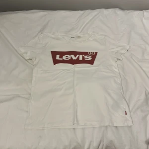 Vit Levi's t-shirt med röd logga - Snygg T-shirt från levi’s, sparsamt använd. Storlek S.
