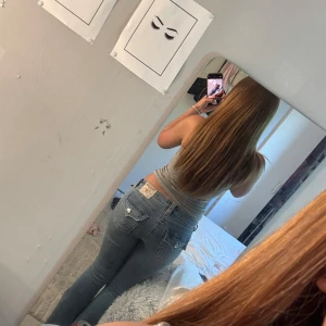 Ljusblå jeans från True Religion - Säljer ett par ljusblå jeans från True Religion med klassiska vita sömmar och snygga fickdetaljer med knappar bak. Jeansen har låg midja och en straight passform som sitter riktigt nice. de har blivit förstora därför jag säljer 🩷pris kan diskuteras, avklippa nertill 