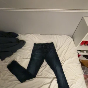 Mörkblå slim jeans Jack & Jones - Säljer ett par mörkblå slim fit jeans från Jack & Jones, modell Glenn. Jeansen har klassisk femficksdesign, snygga kontrastsömmar och är tillverkade i stretchig denim för en bekväm passform. Perfekta för dig som gillar en smal siluett.