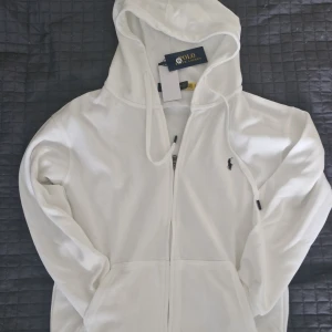 Vit hoodie från Polo Ralph Lauren - Helt ny vit hoodie från Polo Ralph Lauren. Storlek M o sitter som M. Alla tags kvar. Pris kan diskuteras.