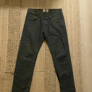 Tiger of SWEDEN jeans  - Snygga grå/blå jeans från tiger of SWEDEN med klassisk femficksdesign och smal passform. Jeansen har en snyggt grå/blå tvätt och är tillverkade i mjukt denimtyg. Perfekta för dig som gillar en stilren och enkel vibe. Jeansen är i nyskick, har knappgylf, och är i slimfit. Sitter som ett par replay anbass, nudie grim Tim eller nudie Lean Dean. Storlek 31/32, sitter mer som 30/32. Nypris 1899:- mitt pris 349:-