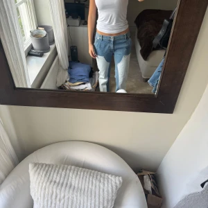 Unika tvåfärgade jeans med patch från Filippa K - Säljer ett par riktigt coola jeans med kontrasterande ljusblåa patch-detaljer framtill. Modellen är rak med normal passform och låg midja. Jeansen har klassisk femficksdesign och är tillverkade i slitstarkt denim. Perfekt för dig som vill sticka ut med en unik look.