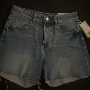 Jeansshorts  - Oanvända högmidjade shorts från HM i stl 38. Dragkedja