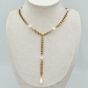 Guldhalsband med pärlor och dropphänge - Unikt halsband i guldtonad kedja med vita pärlor och ett droppformat pärlhänge framtill. Rostfritt stål. 