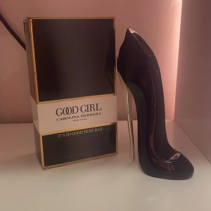 Good Girl parfym från Carolina Herrera - Säljer en ikonisk Good Girl parfym från Carolina Herrera. Flaskan är formad som en svart stilettklack med gulddetaljer och kommer i en lyxig svart och vit kartong med guldkant. En riktigt snygg och unik parfymflaska som sticker ut i hyllan.nästan helt oanvänd, väldigt bra kvalitet.säljer för att jag gillade inte doften så mycket och jag köpte fel variant.