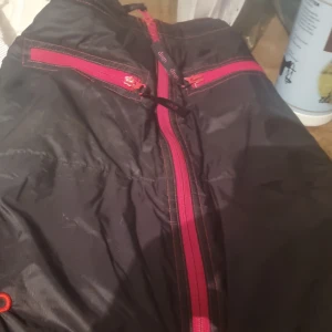 Svart ridtjol med röd dragkedja  - Säljer en svart ridtjol med röd dragkedja 