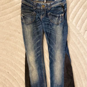 Blåa y2k jeans med kontrastpaneler stl S - Snygga blåa fuga demin Jeans med slitna detaljer och kontrastpaneler i mörkare tyg längs sidorna. Modellen har fram- och bakfickor med dekorativa sömmar jag har även sytt om de lite och så men bra skick.