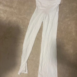 Vita bootcut byxor från Gina Tricot - Säljer ett par vita bootcut byxor från Gina Tricot. Byxorna är högmidjade och har en mjuk och stretchig känsla, perfekta för en chill och trendig look. Passformen är slim upptill och utsvängda nertill. Superbekväma och lätta att styla till olika outfits.