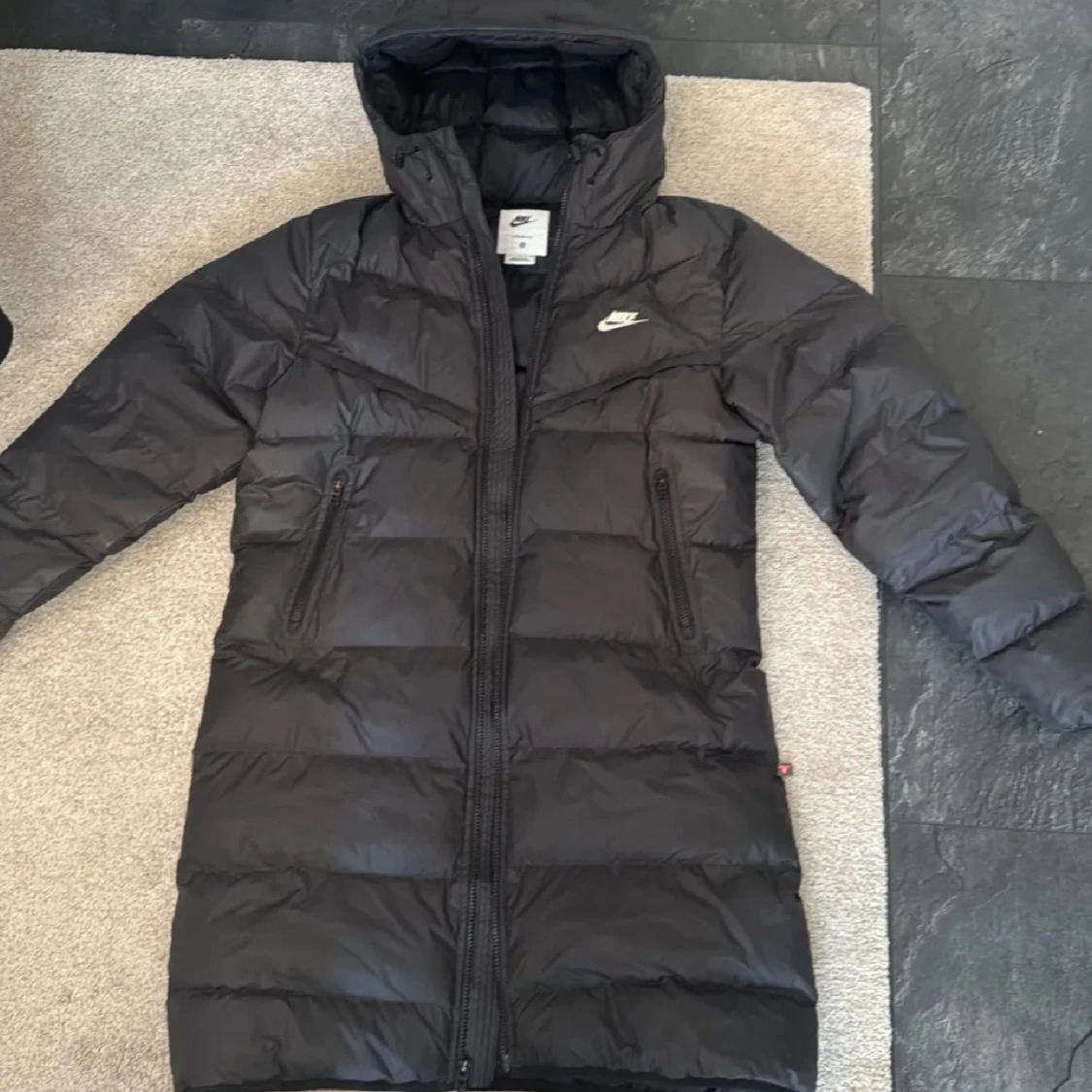 Svart lång dunjacka från Nike