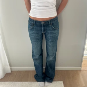 Blå bootcut jeans  - Blå bootcut jeans med brodyr på bakfickorna. Storlek S, Midja: 38x2 cm innerben: 82 cm